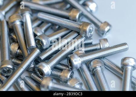Set of screws close up. Macro photo of screws on a white background. Macro photo chromed screws, screw background, steel screw, selective focus. Stock Photo