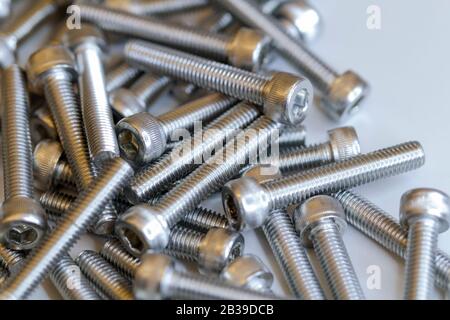 Set of screws close up. Macro photo of screws on a white background. Macro photo chromed screws, screw background, steel screw, selective focus. Stock Photo