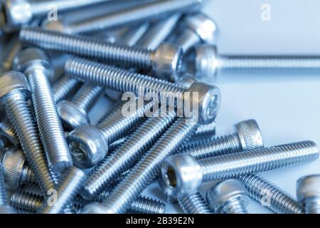 Set of screws close up. Macro photo of screws on a white background. Macro photo chromed screws, screw background, steel screw, selective focus. Stock Photo