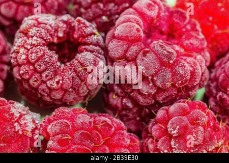 Close-up view on frozen raspberries on a branch, food background. Selective focus. Stock Photo