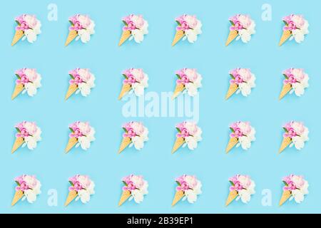 Peonies flowers bouquet in waffle ice cream cone on light blue background. Seamless pattern. Summer concept. Flat lay Stock Photo