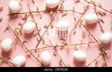White eggs and willow branches on pink background Stock Photo