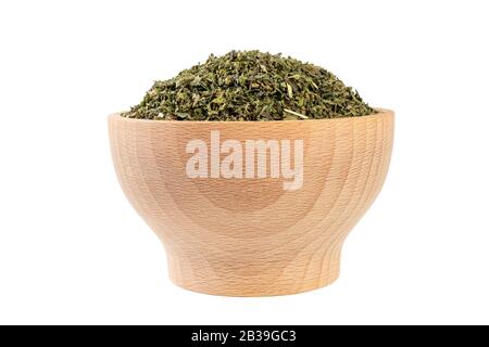 dried nettle herb or in latin Utricae folium in wooden bowl isolated on white background. medicinal healing herbs. herbal medicine. alternative medici Stock Photo