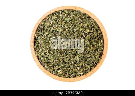 dried nettle herb or in latin Utricae folium in wooden bowl isolated on white background. medicinal healing herbs. herbal medicine. alternative medici Stock Photo