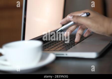 Close up of person using laptop on office desk  Stock Photo