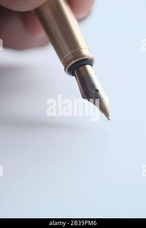Close up of person hand writing with fountain pen on paper  Stock Photo