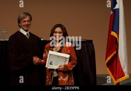 San Antonio Texas USA, April 18, 2004: New U.S. citizen is congratulated by  U.S. Federal Judge John W. Primono during naturalization ceremony at the Institute of Texan Cultures. ©Bob Daemmrich Stock Photo