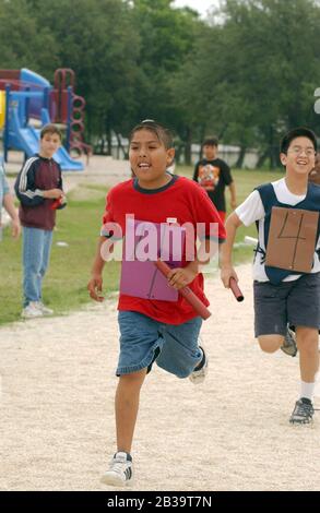 Austin Texas USA, circa 2004: Fourth-grade boys compete in relay run during track and field day at their elementary school. ©Bob Daemmrich Stock Photo