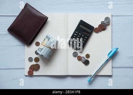 top view of coin, calculator, wallet and notepad on table  Stock Photo