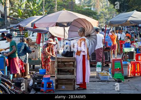 Yangon/Myanmar - February 14, 2020: A nun shops at a market near Shwedagon pagoda, Yangon, Myanmar. Stock Photo