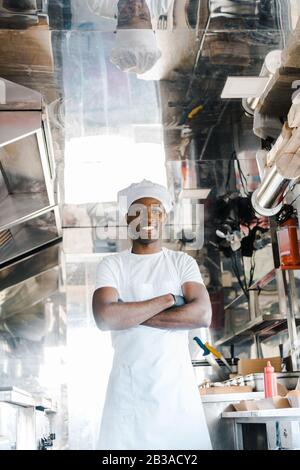 cheerful african american chef standing with crossed arms in food truck Stock Photo