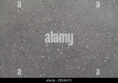 Wet asphalt texture, rough texture with cracks and dents. Stock hoto for web and print, background and wallpaper with empty space for text and design. Stock Photo
