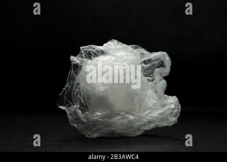 Crushed white clear transparent polyethylene plastic bag on a black background Stock Photo