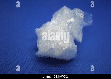 Crushed white clear transparent polyethylene plastic bag on a blue background Stock Photo