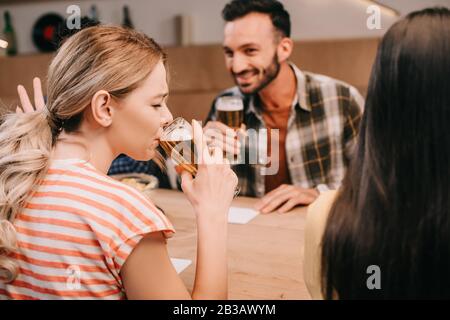 young woman gesturing while drinking light beer with closed eyes Stock Photo