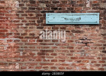 Blank sign on a brick wall of a train station Stock Photo