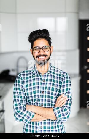 Young indian man standing in the kitchen Stock Photo