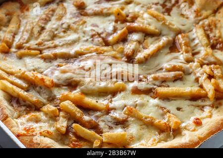 New York style specialty pizza pie with disco fries in gravy and mozzarella cheese toppings Stock Photo