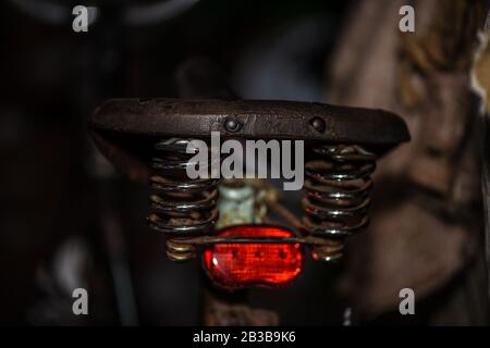 Old fashioned bicycle saddle with red back light and luxury suspension Stock Photo