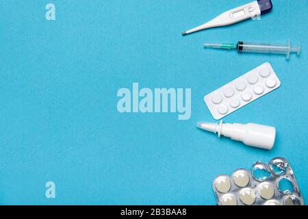 Various medicines for the treatment of a virus as the flu on a blue background with space for copy Stock Photo
