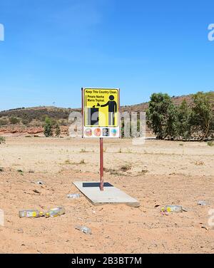 Keep the country clean sign surrounded by empty bottles on the ground, Northern Territory, NT, Australia Stock Photo
