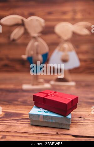 presents boxes in front of wooden easter bunnies couple on old wood background Stock Photo
