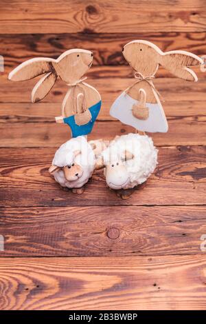 wooden easter bunnies and toy sheep all together on old wood background Stock Photo