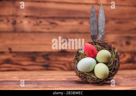iron bunny ears behind an eggs basket on old wood background Stock Photo