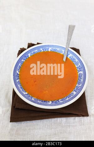 Orange pumpkin puree in a plate with a blue traditional pattern on a plain white background. copy space. Stock Photo