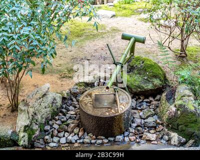 Stone Washbasin at the Ryojani Temple has unique inscription that says 'I learn only to be contented. Stock Photo