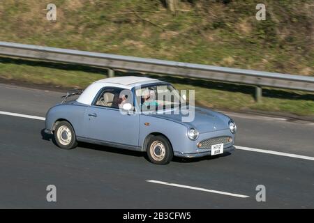 H712AAB Nissan Figaro Grey Car Petrol driving on the M6 motorway near Preston in Lancashire, UK Stock Photo