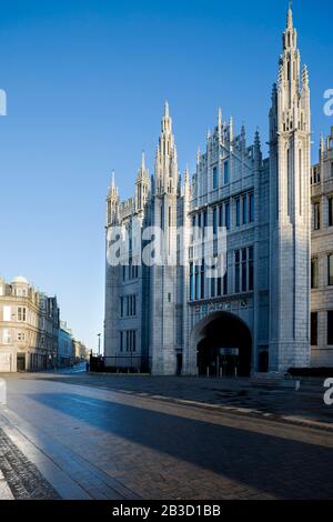 The Facade of Marischal College in Aberdeen, Scotland, bathed in the early morning light with blue sky. Seen from Broad Street Stock Photo