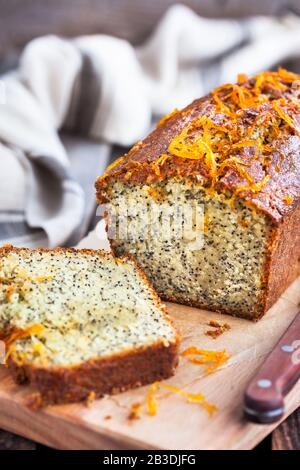 Delicious homemade orange and poppy seeds loaf cake on rustic wooden background Stock Photo