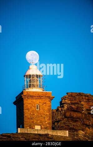 Lighthouse Cape of Good hope and moon in blue sky. South Africa. Stock Photo