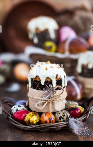 Holiday Easter cakes, hot cross buns and colorful painted eggs on rustic background Stock Photo