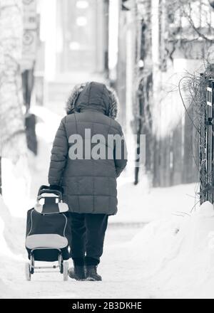 woman walking alone during winter in Montreal, Quebec, Canada Stock Photo