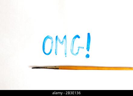 Handwritten OMG text with brush and watercolor paints on white background. Oh my god. Stock Photo