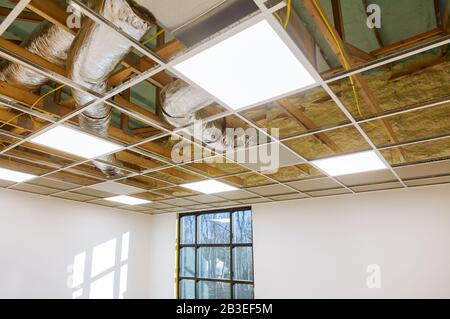 Air conditioning system attached to attic ceiling, foam plastic insulation of a new home HVAC vents being installed Stock Photo