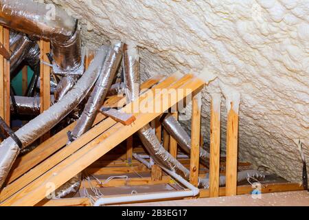 Insulation of attic with insulation material and pipe heating system a building with wooden beams of a roof structure Stock Photo