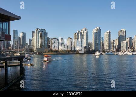 An Aquabus ferry crossing False Creek with with Yaletown skyline in back, Vancouver, BC, Canada Stock Photo