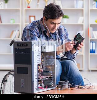 The computer repairman on wheelchair working Stock Photo