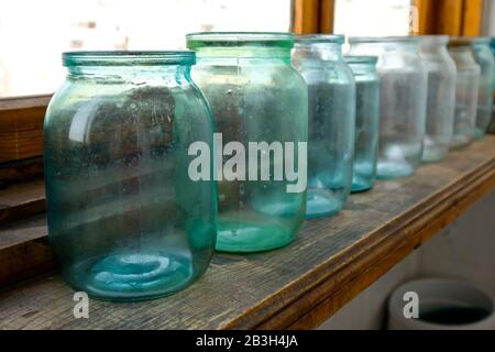 Glass jars for canning are located on the balcony. Dirty unprepared cans. Liter cans for storage Stock Photo