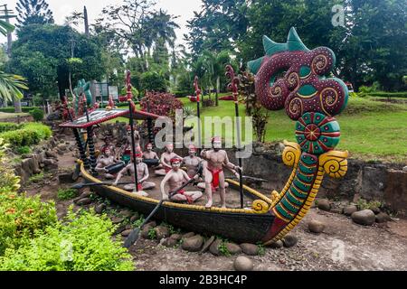 Artistic installation of the traditional boat and people from a local tribe in the aman Mini Indonesia Indah (Beautiful Indonesia Theme Park), Jakarta Stock Photo