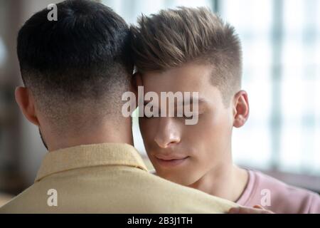 Two men standing next to each other hugging Stock Photo