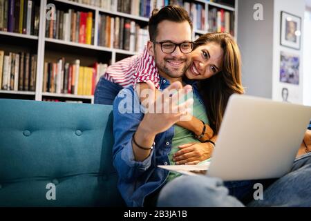 Couple relaxing together in sofa with computer pc having fun. Stock Photo