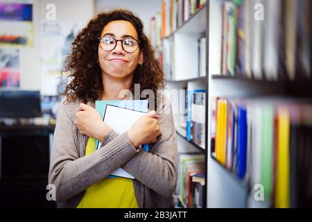 College, study, university and education concept. Cute nerd woman studying in a library Stock Photo