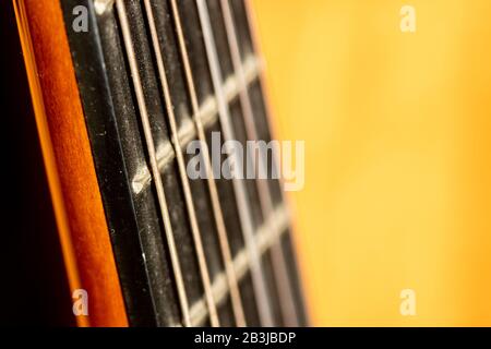 Selective focus on strings of acoustic guitar in morning sunlight Stock Photo