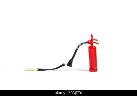 Micro fire extinguisher close to a burnt match against a white background, macro shot Stock Photo