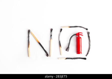 Sign NO made of burnt matches and a tiny fire extinguisher inside Stock Photo