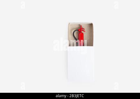 Tiny fire extinguisher inside a white match box, top view, isolated on white Stock Photo